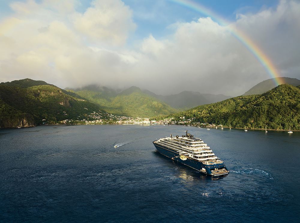 ritz carlton yacht in water with rainbow